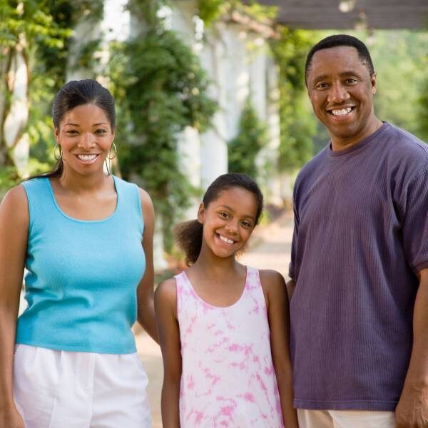 A mother, father, and daughter enjoying time together at a botanical garden.